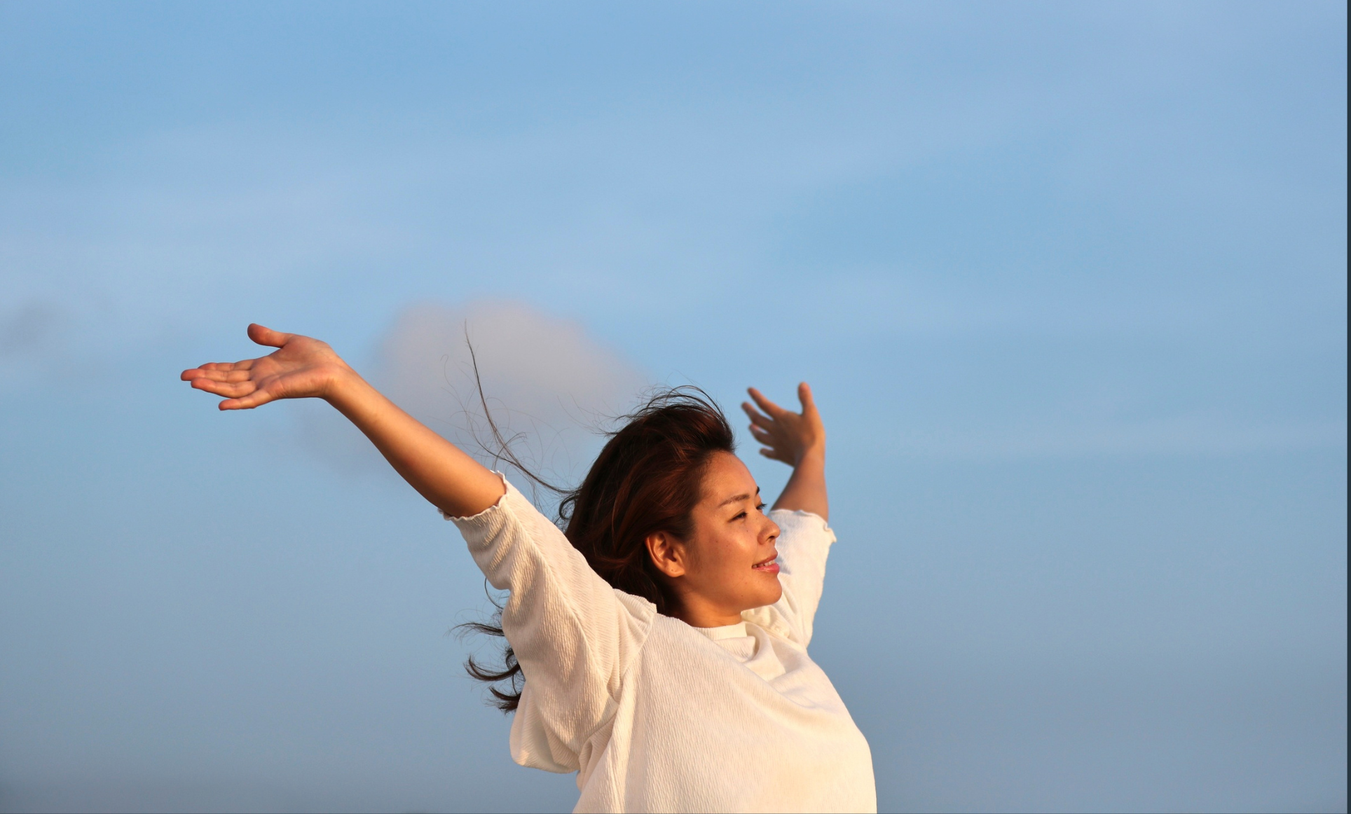 Chica con los brazos abiertos como signo de libertad